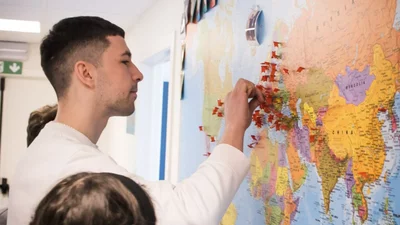 Internationale studenten aan een wereldkaart